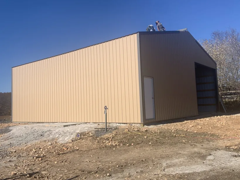 Crew finishing a post-frame roof for D.T. Construction